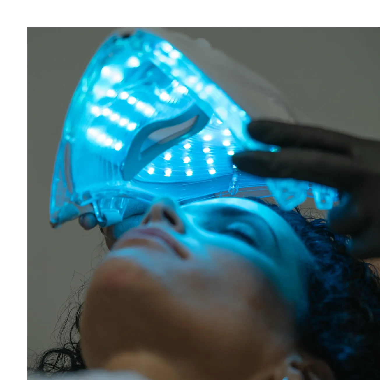 Person undergoing LED light facial treatment.